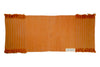 Annatto orange organic cotton yoga mat laid flat, with tasselled ends