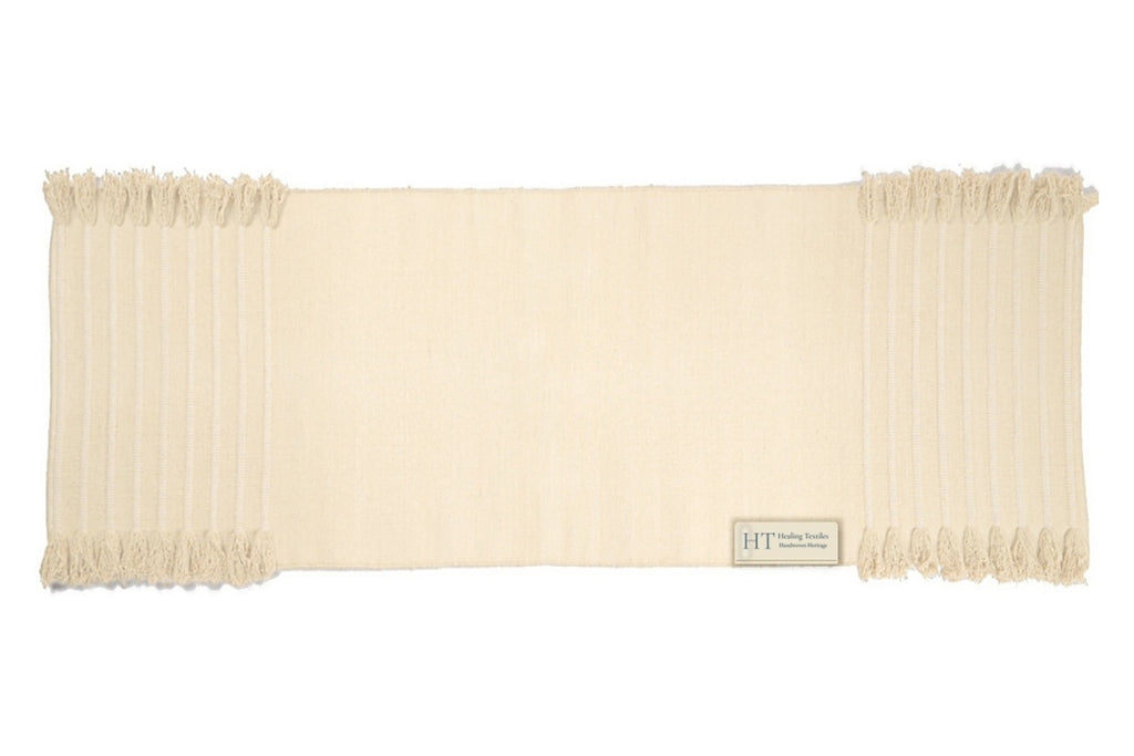 Ayurvedic Plain natural white organic cotton yoga mat laid flat, with tasselled ends