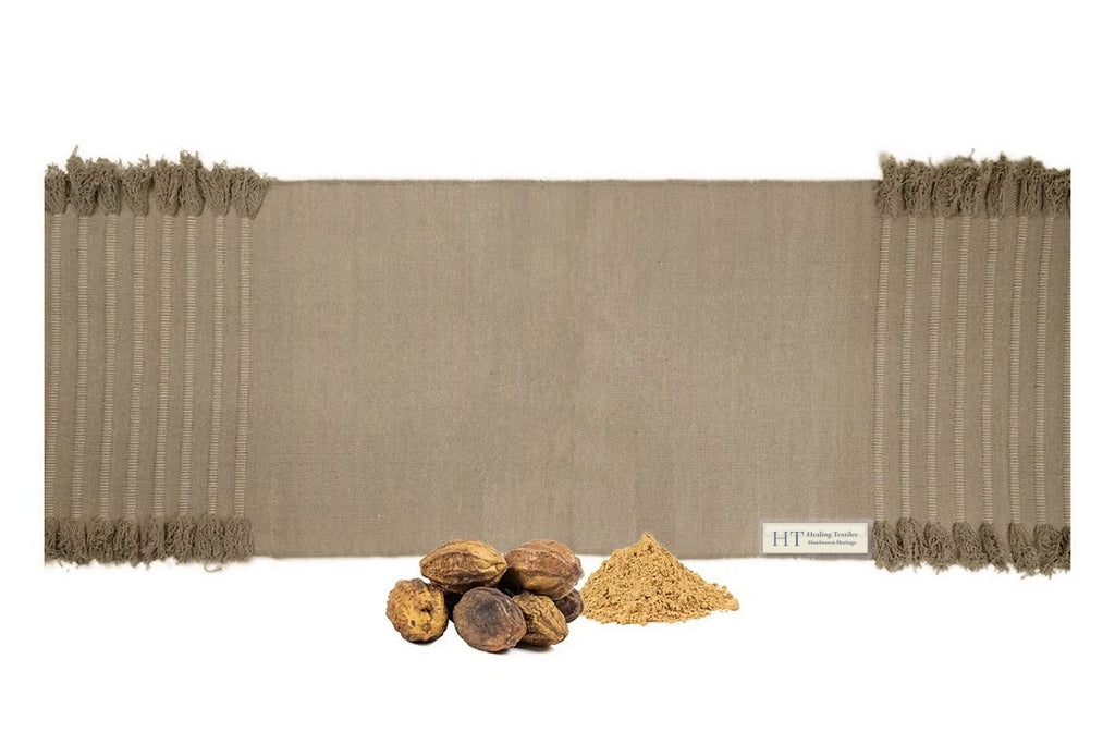 Myrobalan clay-brown organic cotton yoga mat in a lighter shade, with whole myrobalan fruits and powder in front