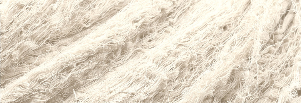 Close-up of undyed raw cotton threads in natural white