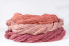 Skeins of sappanwood-dyed cotton in coral, blush pink and deep rose